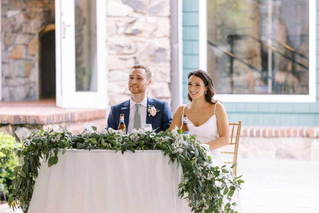 Bride and groom sitting at a sweetheart table